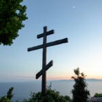 Huge wooden Orthodox eight-pointed cross against the sky after sunset on Mount Athos